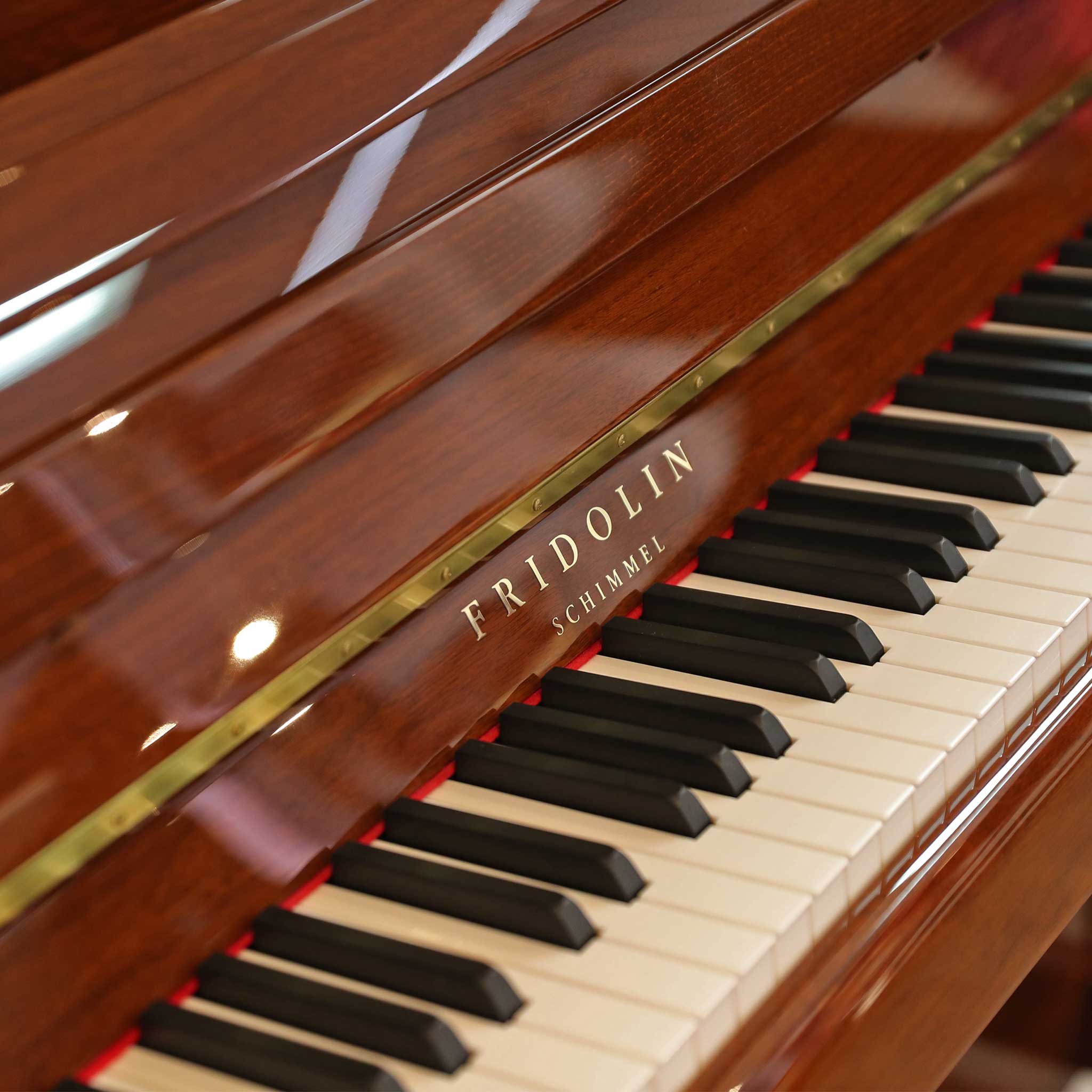 Klavier Fridolin Schimmel Nussbaum poliert detail logo und tasten