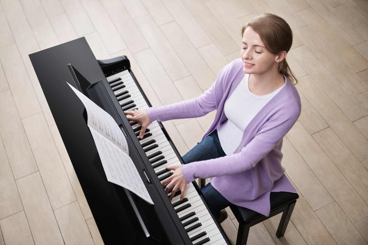 Frau spielt nach Noten an einem Yamaha Clavinova CLP-875