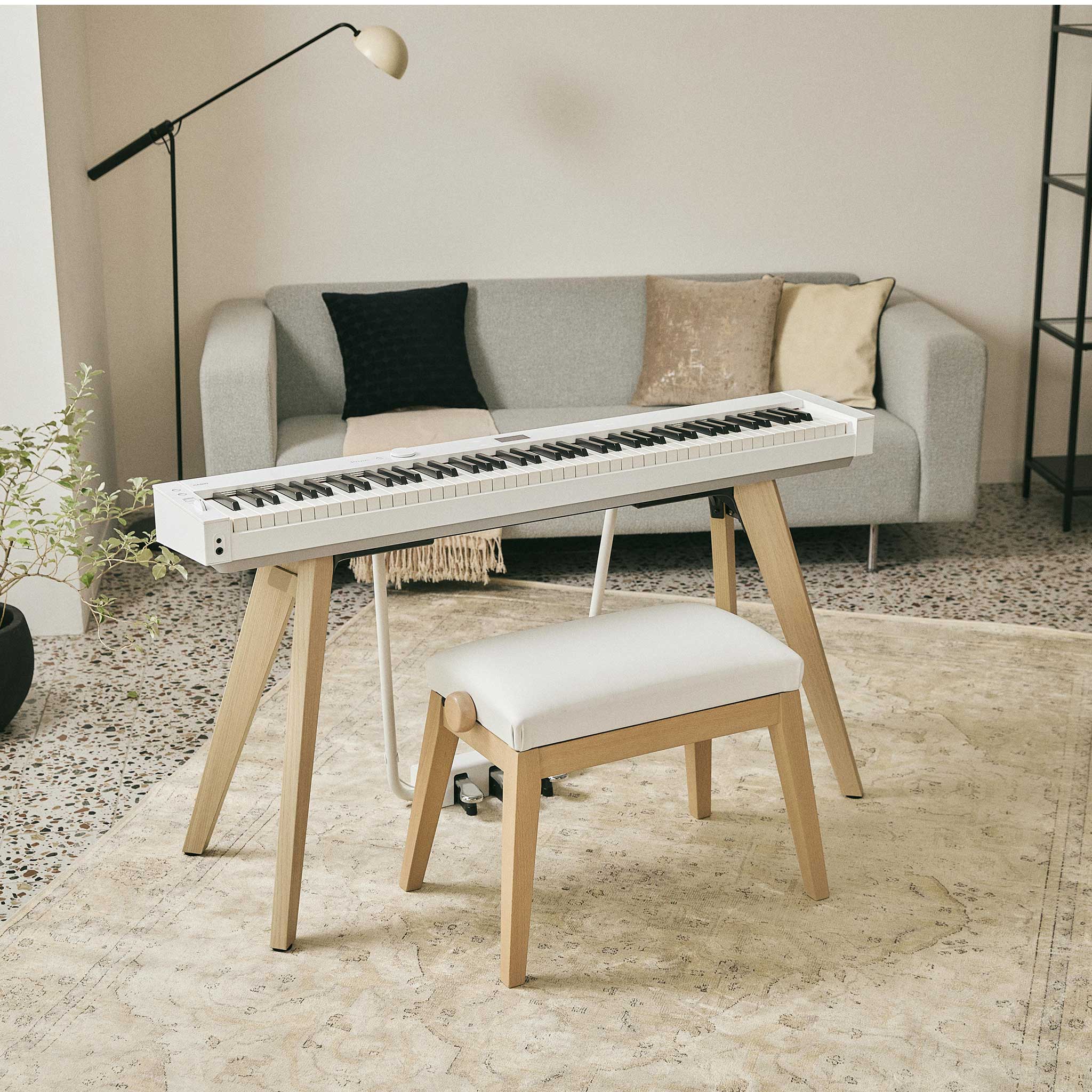 Casio PX-S7000WE Privia im Wohnzimmer mit Klavierbank und Teppich