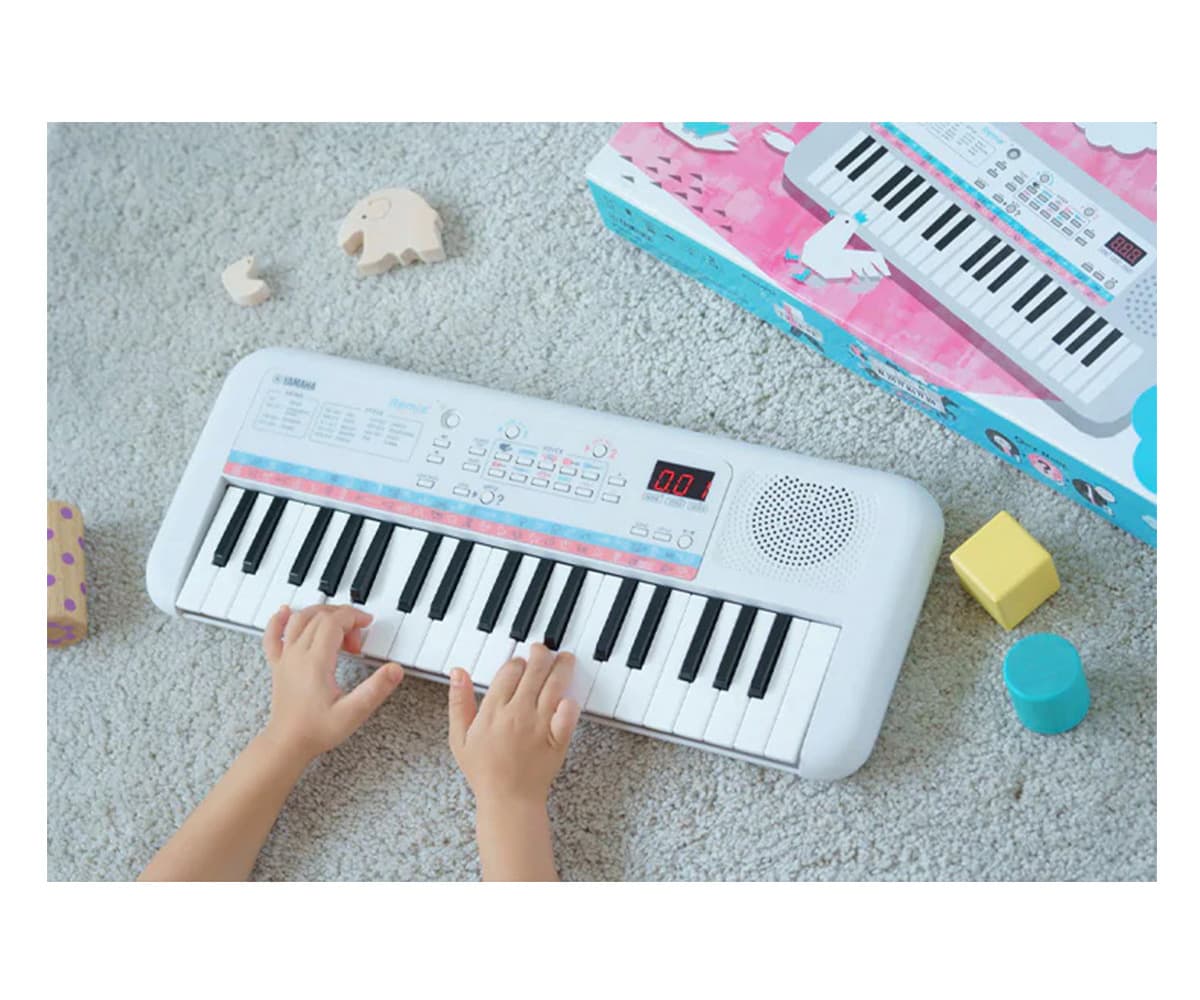 Yamaha PSS-E30 Mini Keyboard top mit händen am teppich

