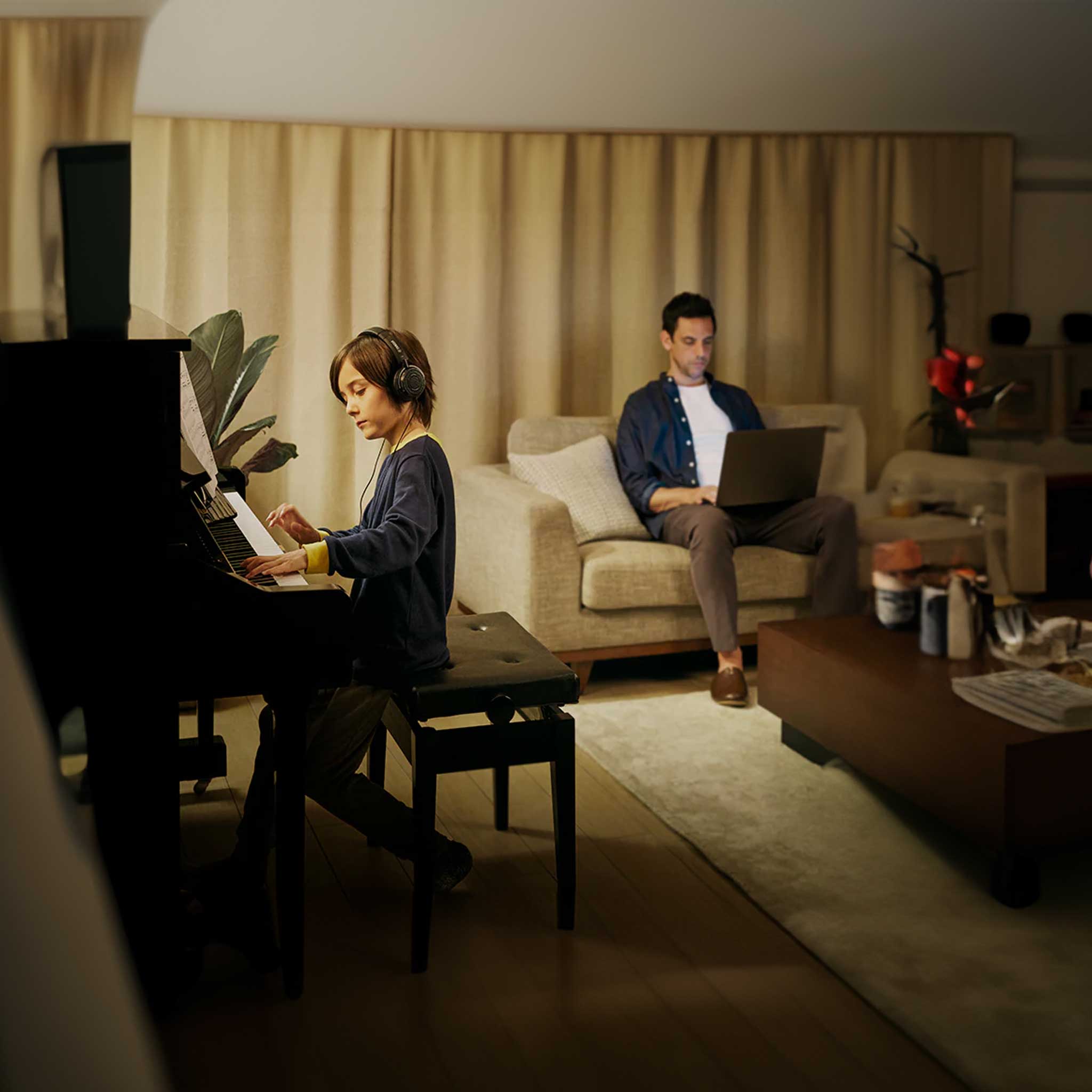 yamaha b2 silent piano kind spielt im silent modus mit kopfhörer vater mit laptop daneben