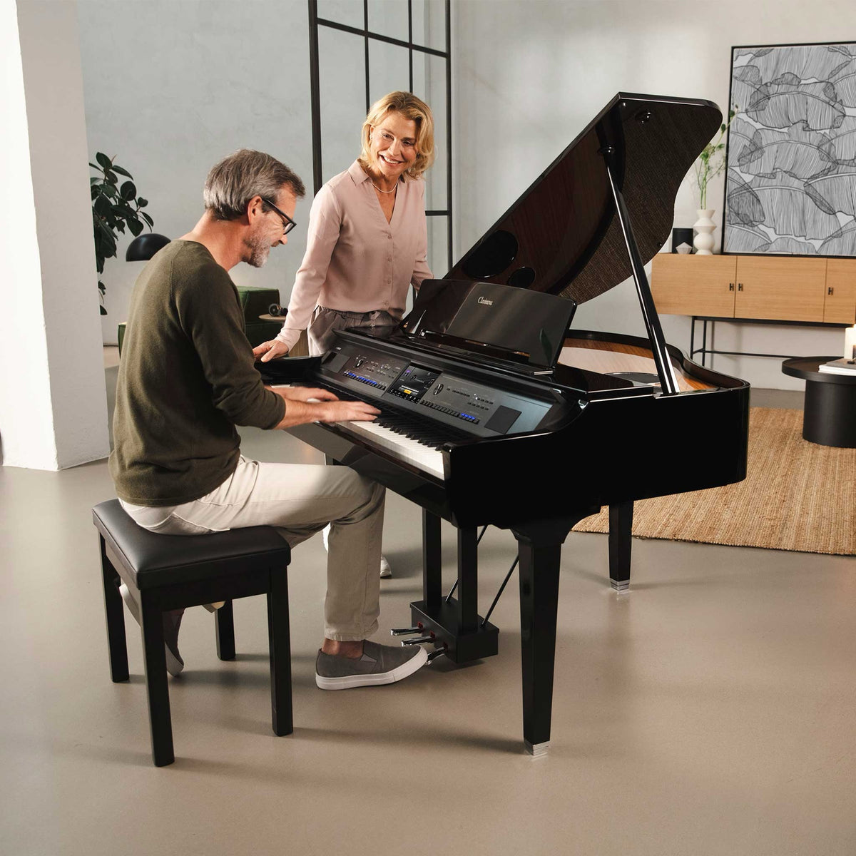 Paar am Yamaha Clavinova CVP-909GP Digitalflügel in einem hellen Wohnraum